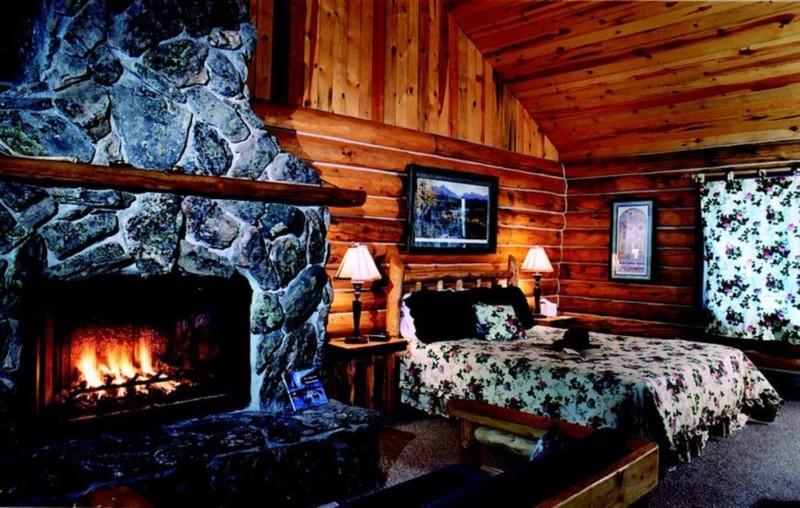 Log cabin designed bedroom with fireplace