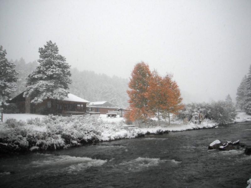 Snow-covered buildings along a mountain stream