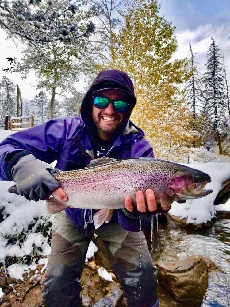 Man holds large rainbow trout up to the camera