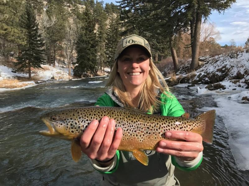 Woman holding up large brown trout